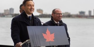Pierre Poilievre speaks with MPs Harb Gill and Chris Lewis outside the Windsor Club in Windsor, Ont., March 13, 2026.