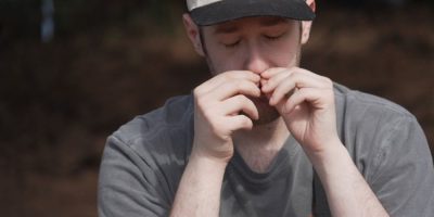 Participant smells a crushed conifer twig during a guided forest bathing session at J.C. Raulston Arboretum in Raleigh, North Carolina