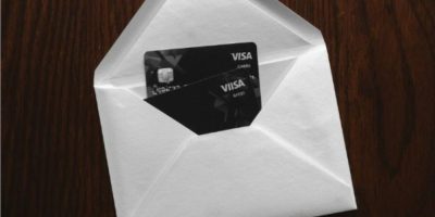 Two Visa credit cards placed beside a sealed envelope in a fraud prevention image from Barrie Police Service