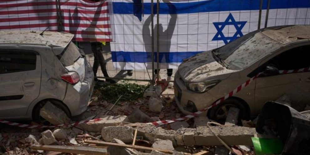 Israeli and U.S. flags hung at a site in Ramat Gan struck by an Iranian missile, which killed two people on March 18, 2026.
