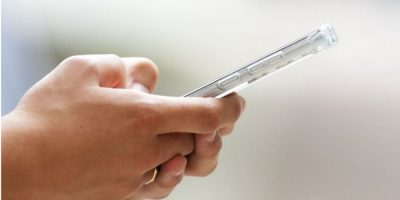 A person uses a cellphone in Ottawa, illustrating Ontario’s consideration of a potential school property cellphone ban and stricter social media rules for students.