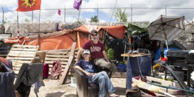 Will House and Jen Draper stand outside their home within a large homeless encampment in Kitchener, Ontario, on June 27, 2022.