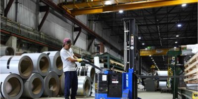 Worker operates a forklift near steel coils at a manufacturing plant in Ottawa.