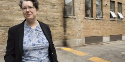 Rabbi Lisa Grushcow stands near a burnt-out window at a synagogue in Westmount, Que., in June 2026.